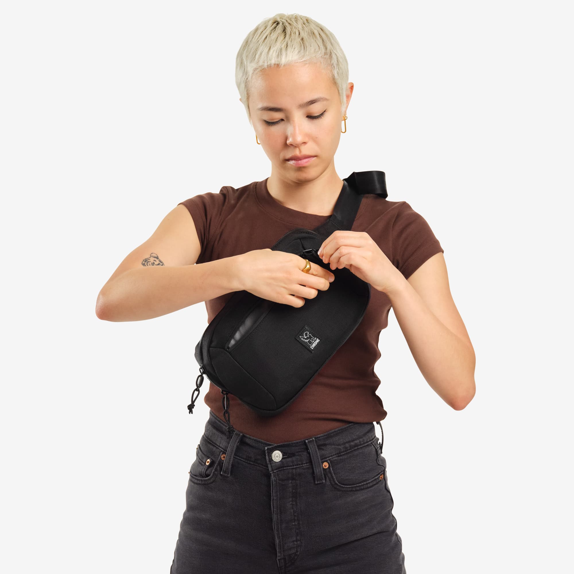 Ziptop Waistpack sling in black woman unzipping it