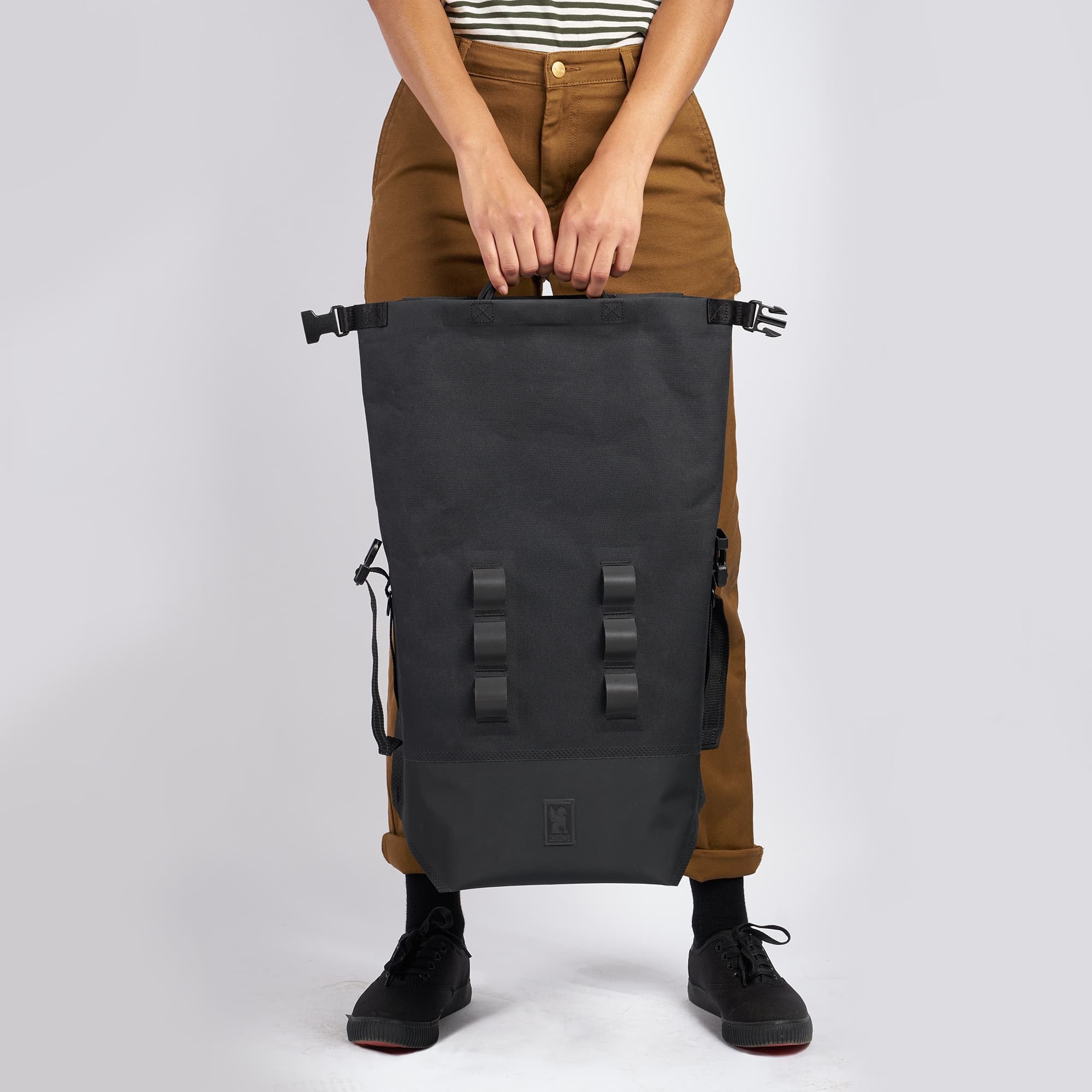 Waterproof 20L backpack in black top handles held by a woman