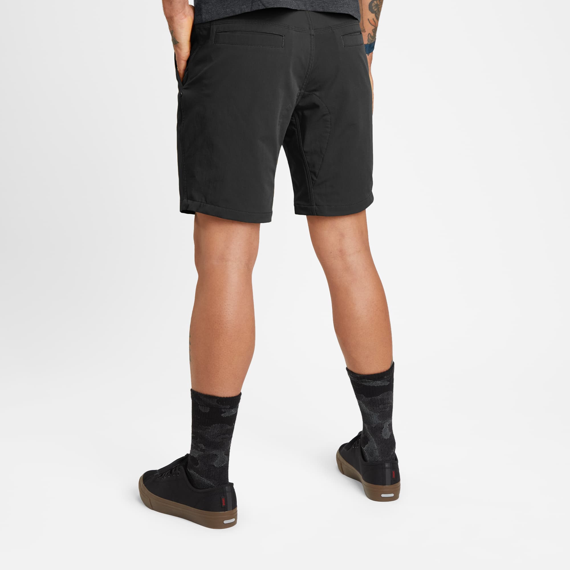 Men's 9" inseam Folsom Mid Short in black worn by a man back view #color_black