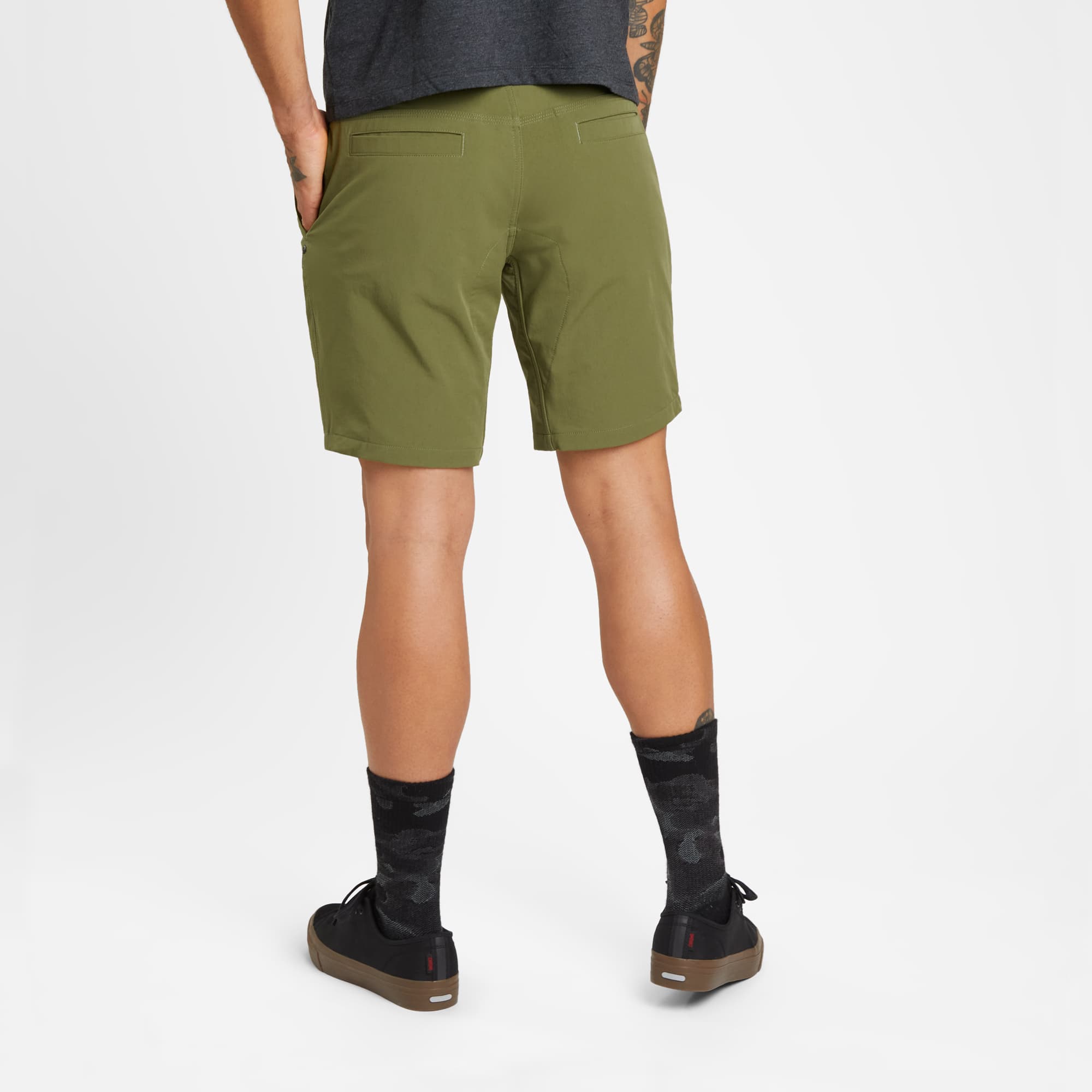 Men's tech Folsom Mid Short in green worn by a man back detail #color_olive branch