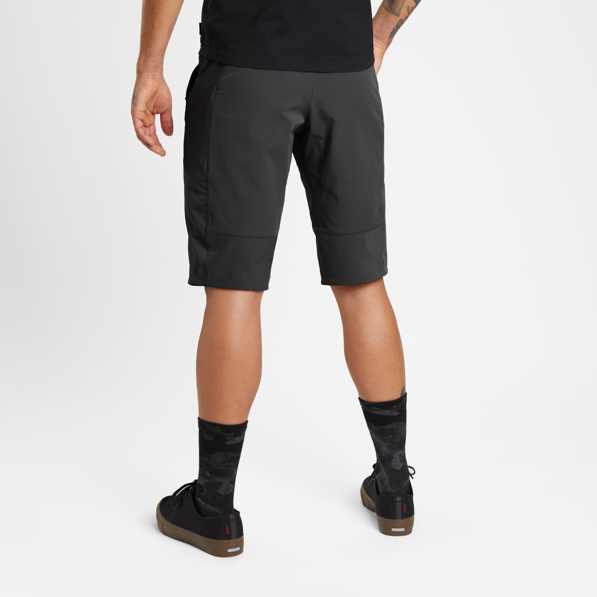 Men's tech Sutro Short in black worn by a man back view #color_black