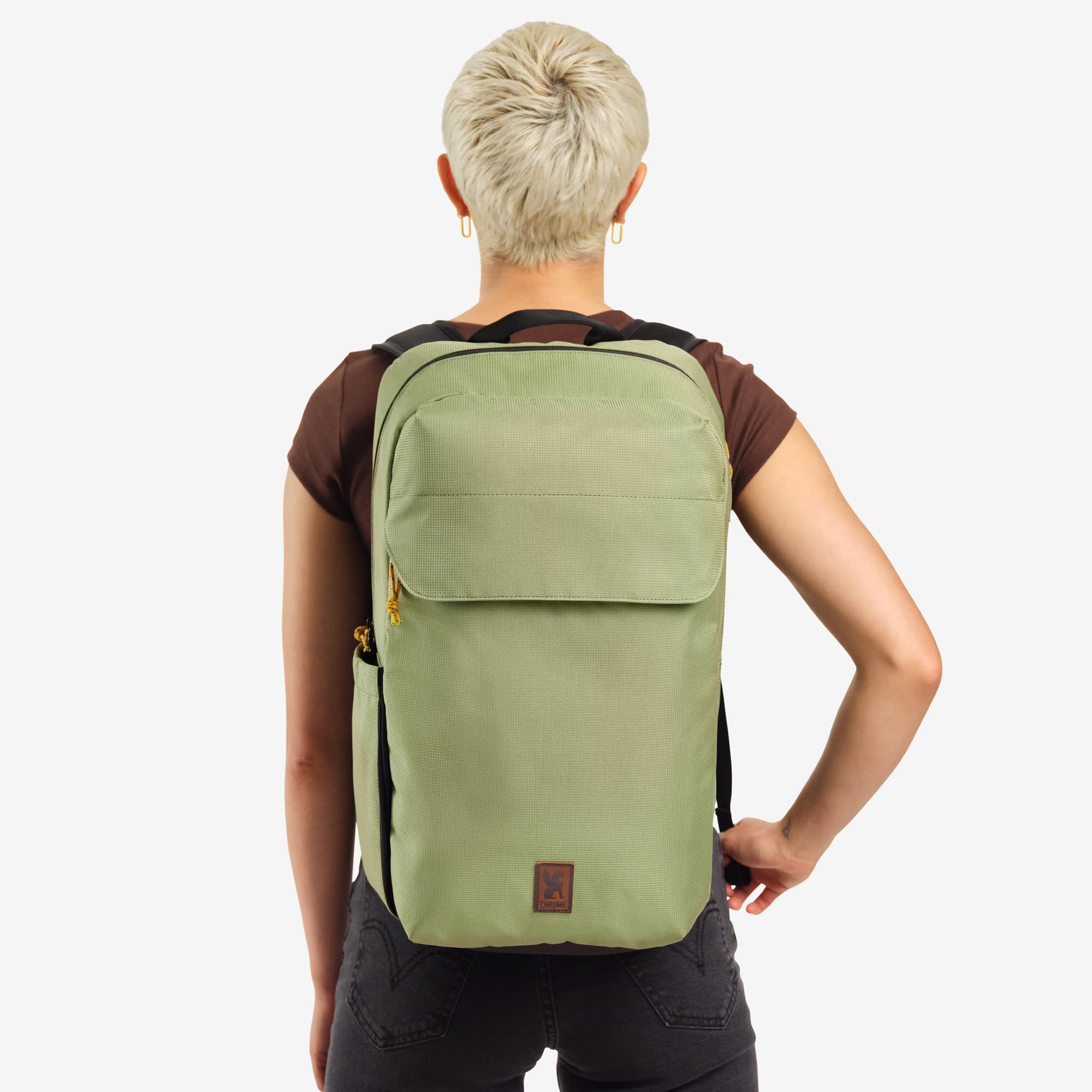 Ruckas 23L Backpack in green worn by a woman #color_oil green