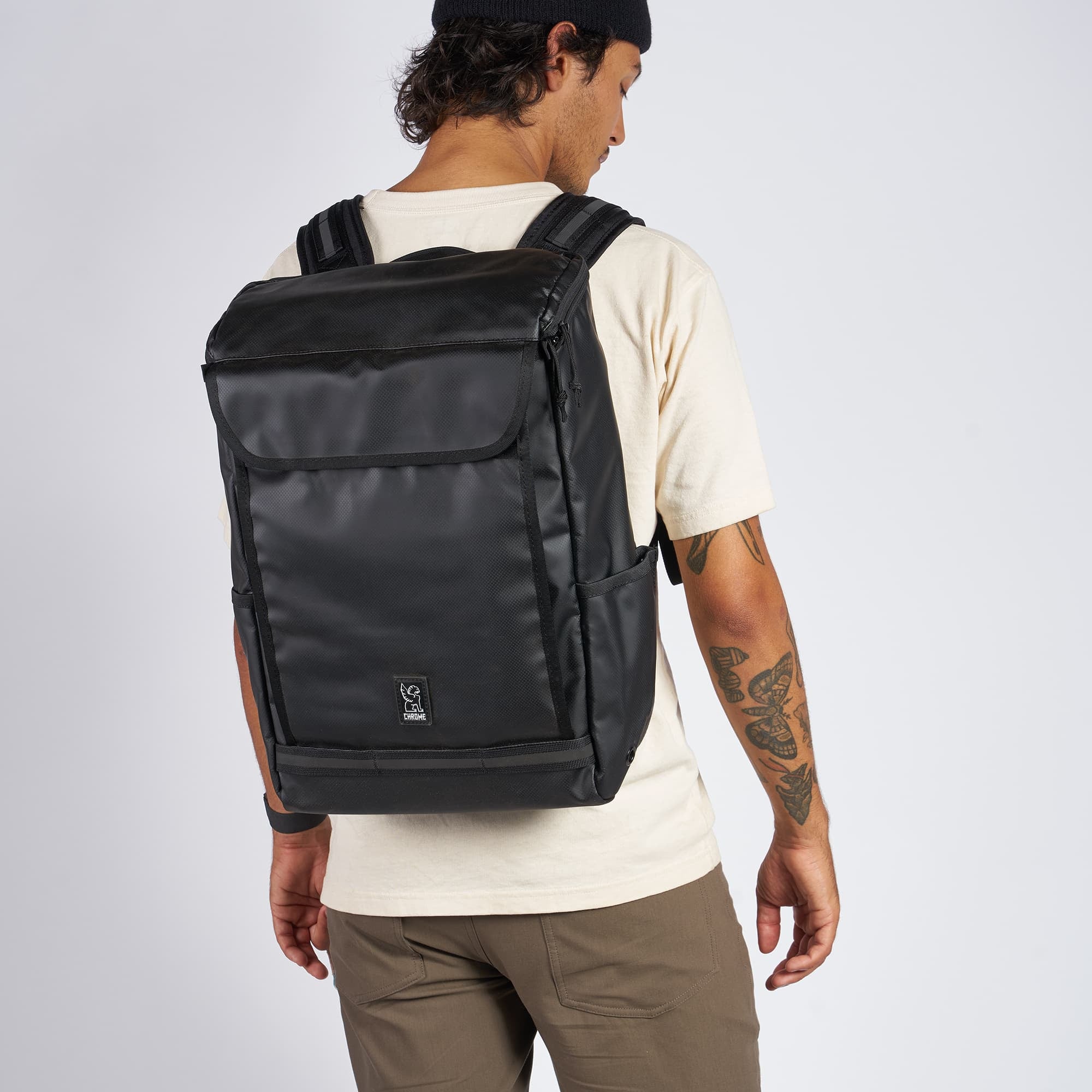 Weather resistant Volcan Backpack in black tarp worn by a man #color_black tarp