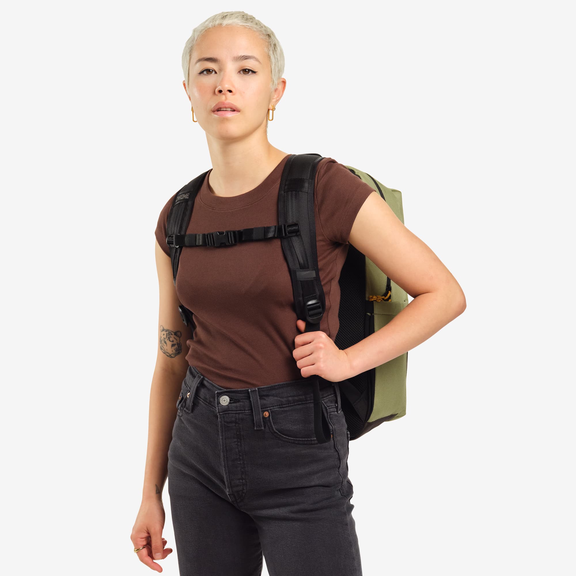 Ruckas 23L Backpack in green worn by a woman front view #color_oil green