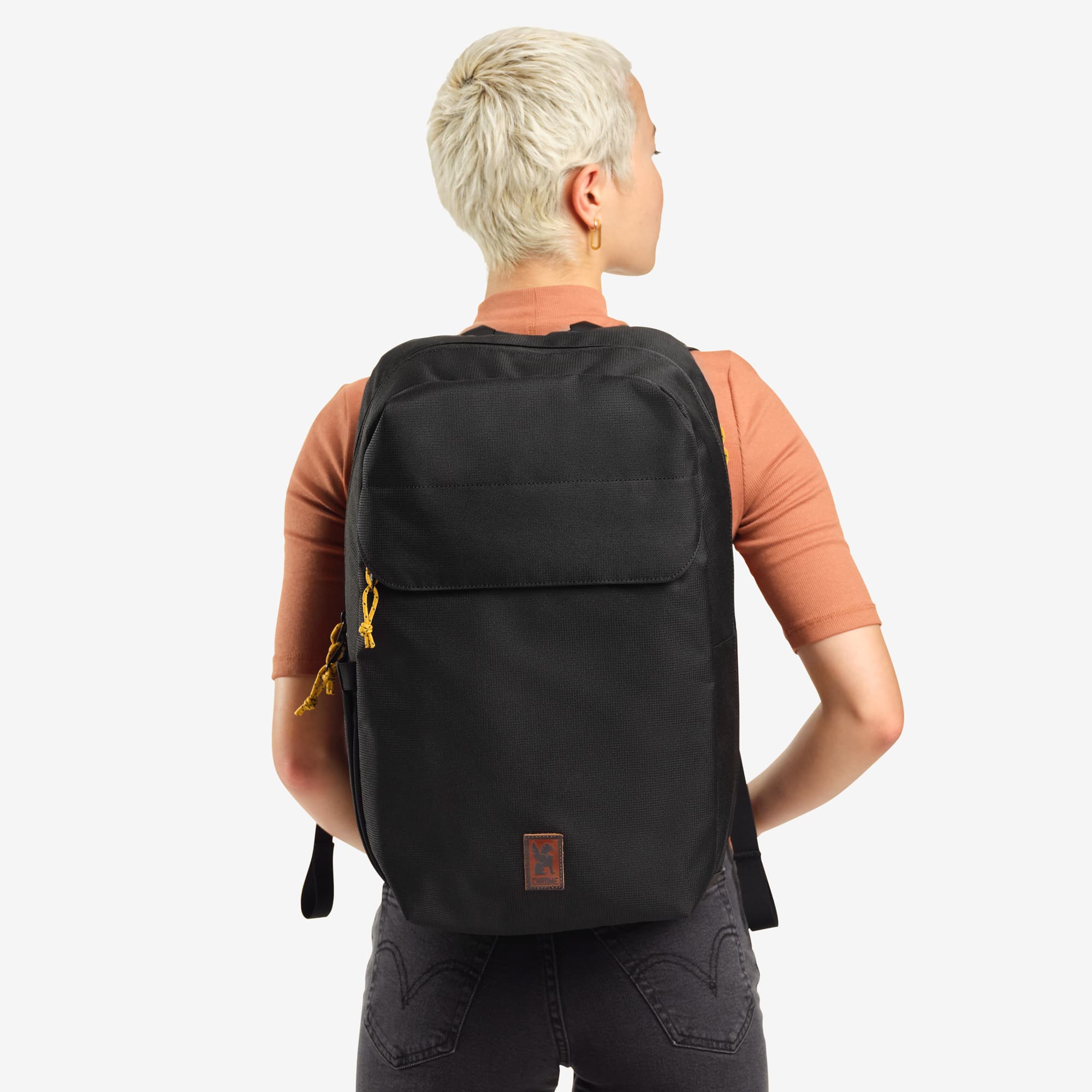 Ruckas 23L Backpack in black worn by a woman #color_black