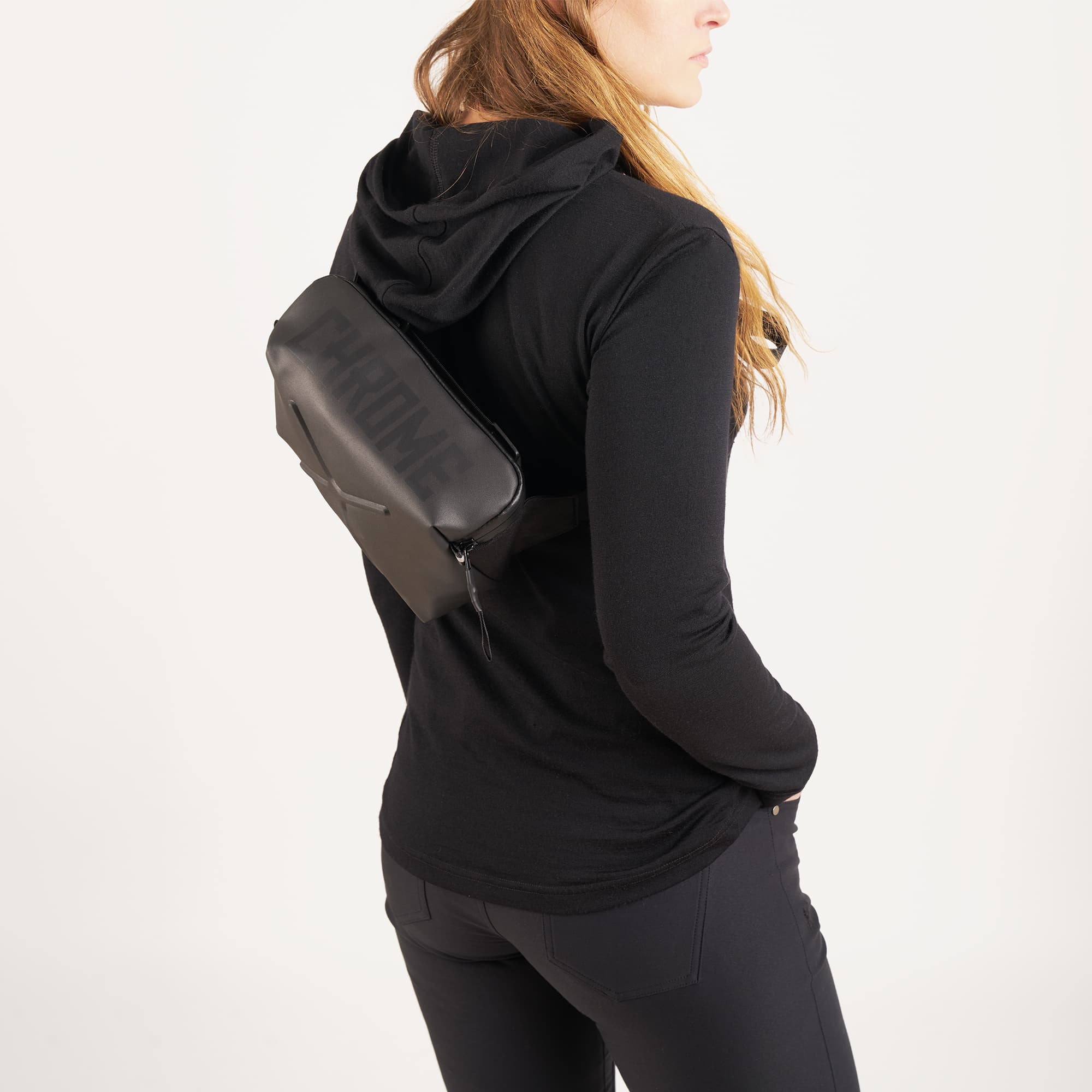 Helix Handlebar bag in black worn as a sling by a woman