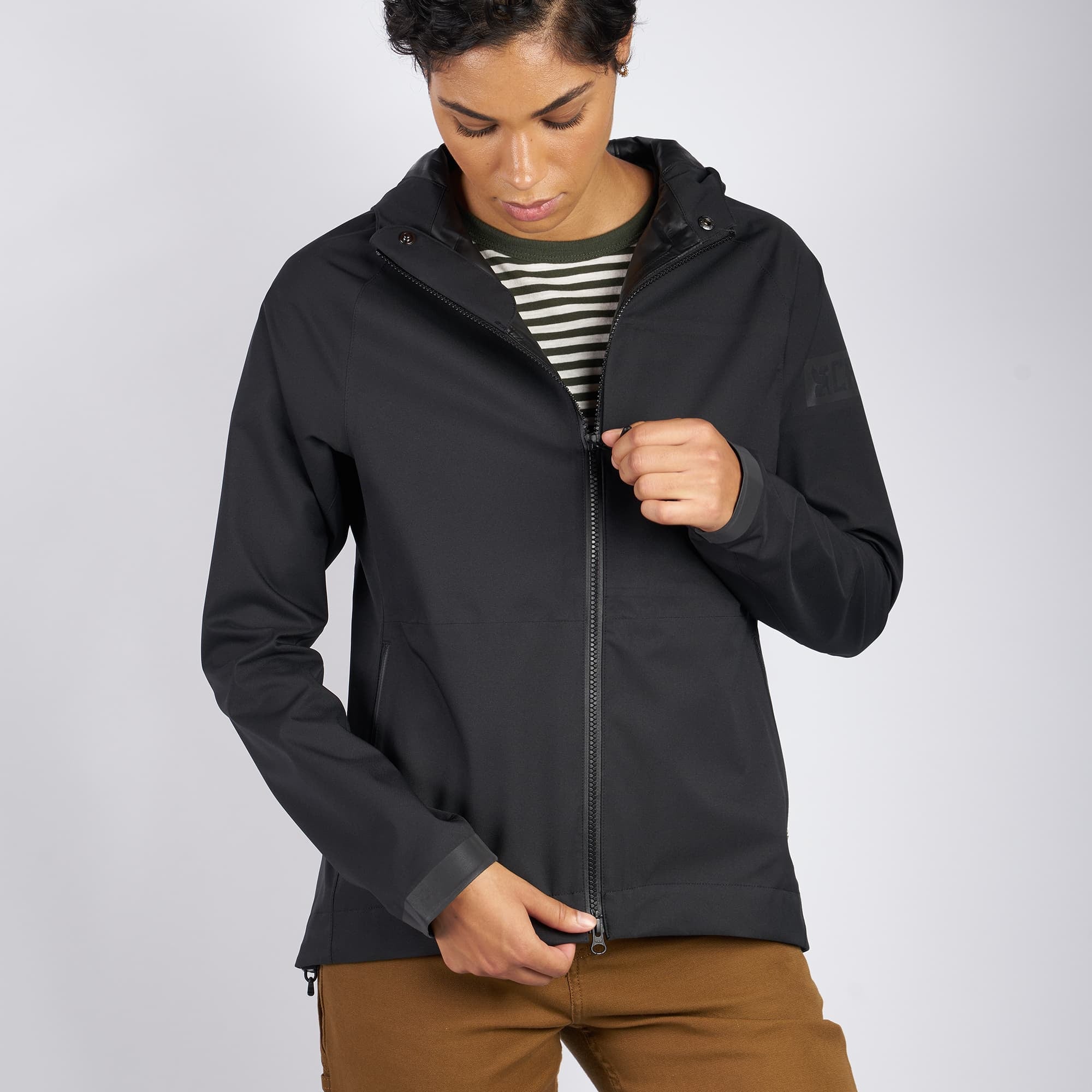Women's waterproof jacket in black worn by a woman zipper highlight
